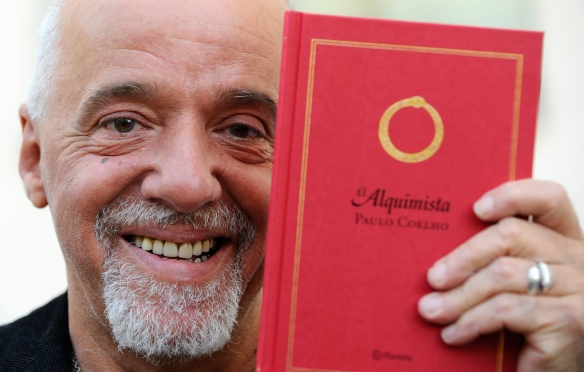 Brazilian writer Paulo Coelho holds a copy of his novel The Alchemist in Aviles, northern Spain